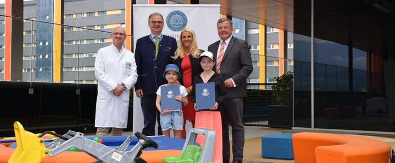 Ursula Mattersberg mit LR Bernhard Tilg, Rektor Wolfgang Fleischhacker, Klinikdirektor Thomas Müller (v. re. n. li.) und den beiden AssistentInnen Suha (li. vorne.) und Leonie (re. vorne) bei der Vertragsunterzeichnung. Foto: MUI/D. Bullock.