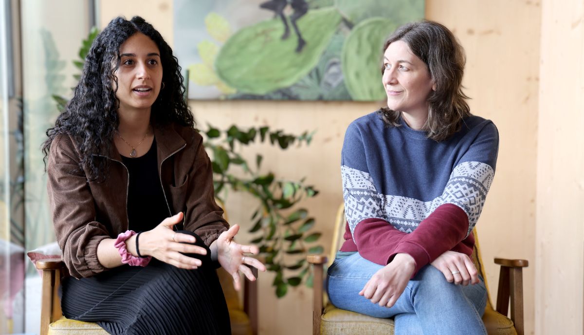 Taye und Fürhapter sitzend nebeneinander im Gespräch mit einer dritten nicht sichtbaren Person, Taye gestikuliert mit den Händen